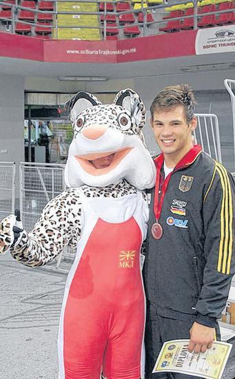 Ein glücklicher KFC-Ringer Erik Thiele mit dem EM-Maskottchen von Skopje.