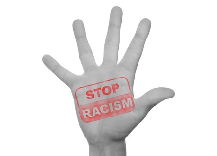 Grafik: Hand mit Schriftzug Stop Racism.